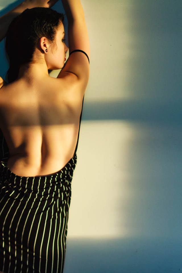 Deven Skye in an open-back dress in window light