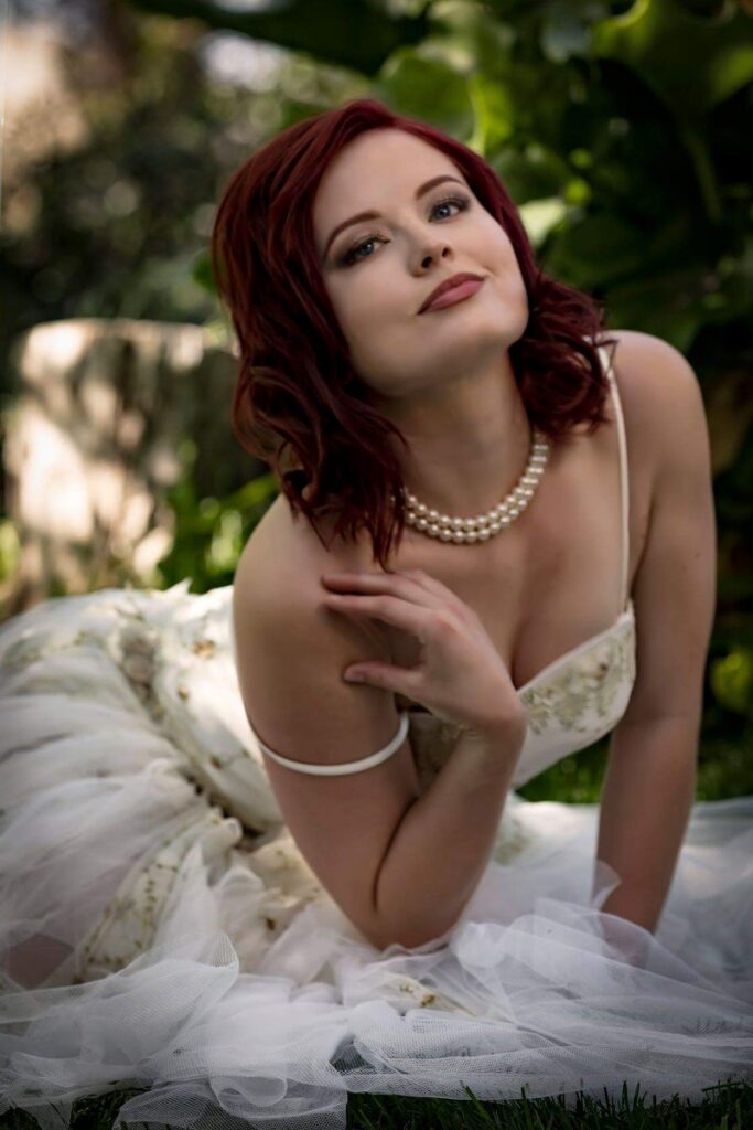 Deven Skye in a white gown and pearls